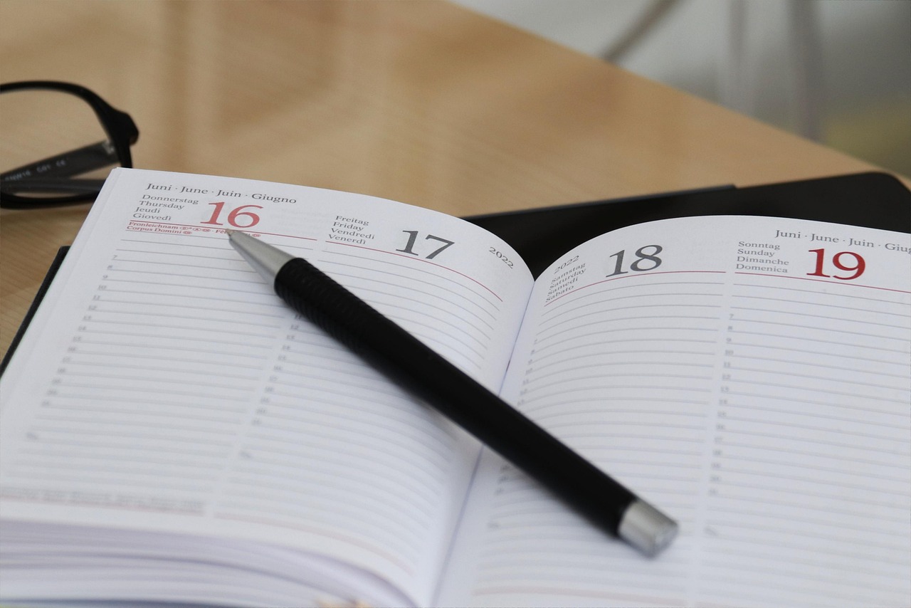 Open event planner journal with calendar pages and handwritten notes